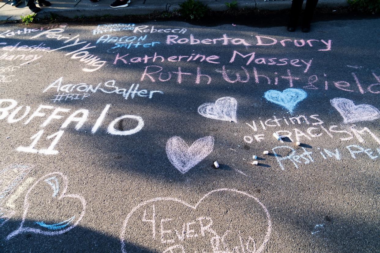 Chalk writings noting the names of victims are inscribed on Landon Street, near the Tops supermarket in Buffalo.  (Joshua Thermidor for NBC News)