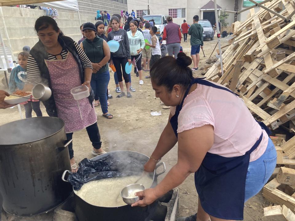 A woman serves dinner of rice and beans to migrants at Templo Embajadores de Jesus, Tijuana's largest migrant shelter, Thursday, Oct. 13, 2022, in Tijuana, Mexico. The Biden administration's policy shift on Venezuelan migrants may pose an enormous challenge to overstretched Mexican shelters. The U.S. has coupled plans to let up to 24,000 Venezuelans apply online to fly to the U.S. for temporary stays with a pledge to immediately turn back Venezuelans who cross the border illegally from Mexico.(AP Photo/Elliot Spagat)