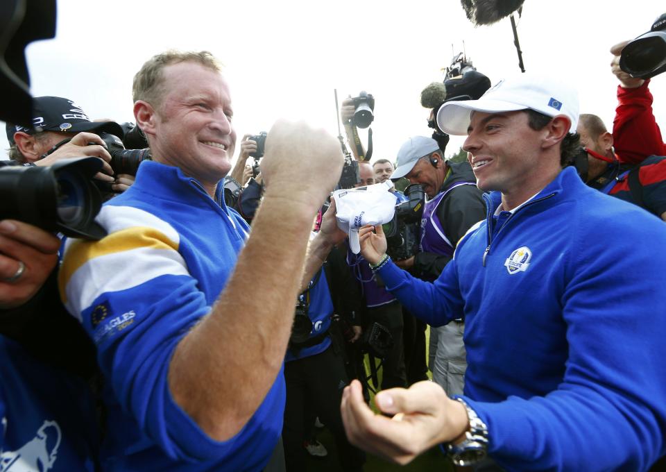 Team Europe golfer Jamie Donaldson (L) celebrates with teammate Rory McIlroy after winning his match against U.S. player Keegan Bradley to retain the Ryder Cup for Europe on the 15th green during the 40th Ryder Cup at Gleneagles in Scotland September 28, 2014. REUTERS/Eddie Keogh (BRITAIN - Tags: SPORT GOLF TPX IMAGES OF THE DAY)