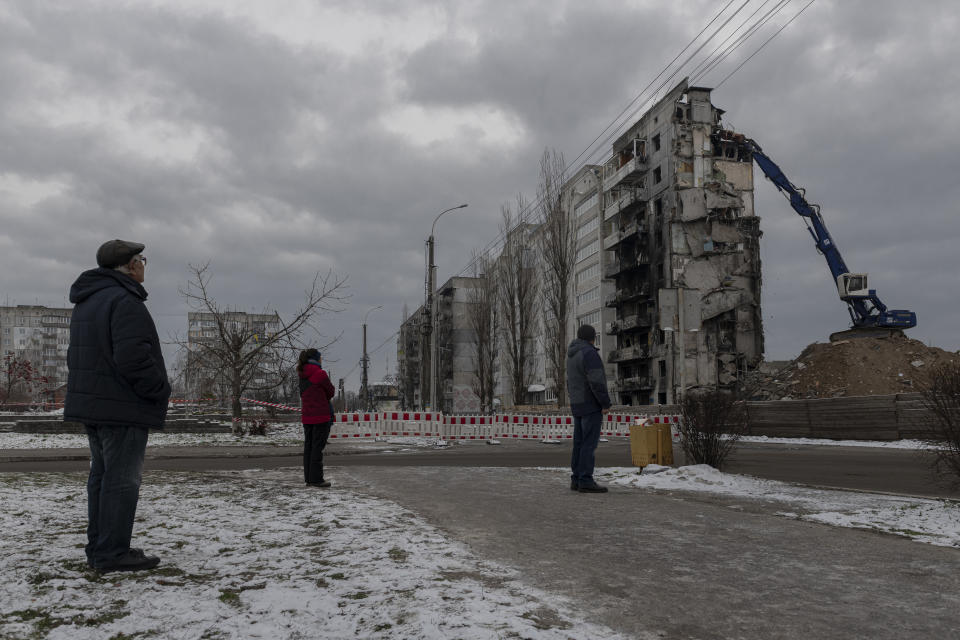 Local residents watch as a bombed building is dismantled in Borodyanka, Kyiv region, Ukraine, on Dec. 13. 