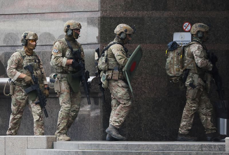 Members of the Security Service of Ukraine (SBU) enter a building where an unidentified man reportedly threatens to blow up a bomb in a bank branch, in Kyiv