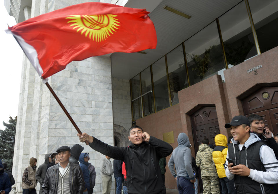 Protesters gather in front of the government headquarters on the central square in Bishkek, Kyrgyzstan, Tuesday, Oct. 6, 2020. Protesters have clashed with police in Kyrgyzstan's capital during a demonstration against the results of a parliamentary election. Early results in the election gave the majority of votes to two parties with ties to the ruling elites amid allegations of vote buying. (AP Photo/Vladimir Voronin)