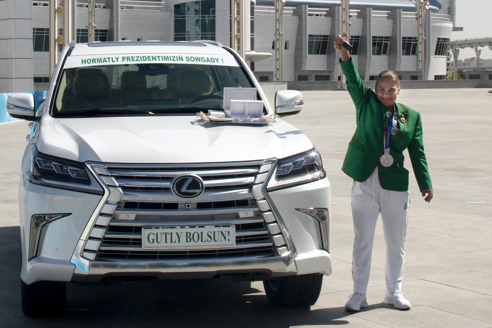 ADDS CLASS OF MEDAL Polina Guryeva, Olympic silver medalist in the women's 59kg weightlifting event at the 2020 Summer Olympics, shows the key of her new car, a gift from the Turkmenistan President at a lavish ceremony in Ashgabat, Turkmenistan, Saturday, Aug. 21, 2021. Turkmenistan has lauded its first Olympic medal winner at a lavish ceremony where she was showered with gifts. Guryeva, 21, lifted a total 217 kilograms in the 59-kilogram category, edging Mikiko Andoh of Japan for second place at the Tokyo Games. (AP Photo/Alexander Vershinin)