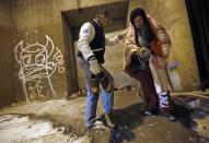 Doctor Patrick Angelo hands over the shoes off his feet to help a homeless man under the overpasses on Lower Wacker Drive in Chicago, Illinois, January 7, 2014. Angelo visits the homeless several times a week to hand out food, clothing and blankets to those living on the streets with the funding coming from his oral surgery medical practice and profits from his healthcare company. Angelo is in his 13th year doing charity work. Picture taken January 7, 2014. REUTERS/Jim Young (UNITED STATES - Tags: SOCIETY POVERTY TPX IMAGES OF THE DAY)