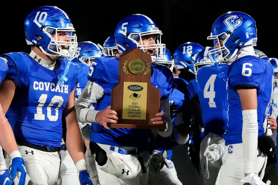Covington Catholic quarterback Evan Pitzer (5) carries the state semifinals trophy after winning the KHSAA Class 4A state semifinal Nov. 24 against Paducah Tilghman.