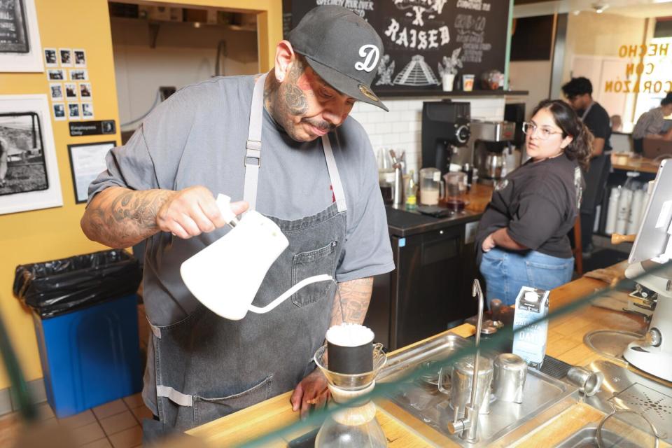 A barista pours a drink.