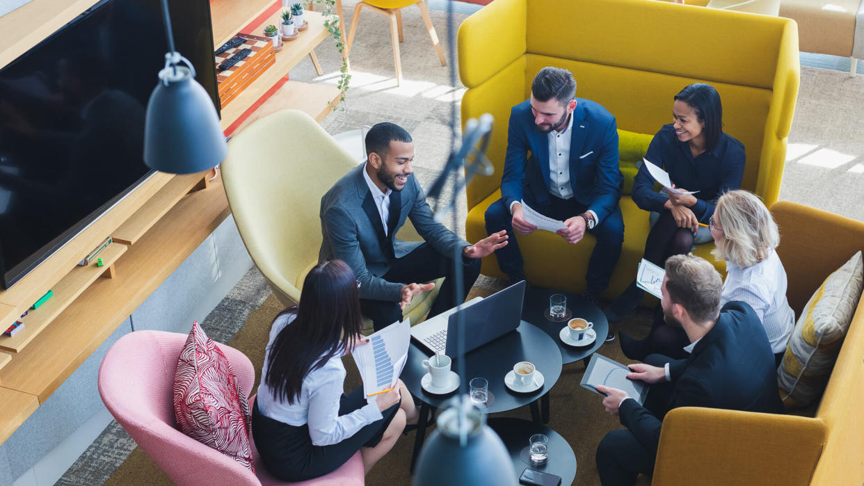 A group of cheerful business people attending an informal meeting in the coffee shop.