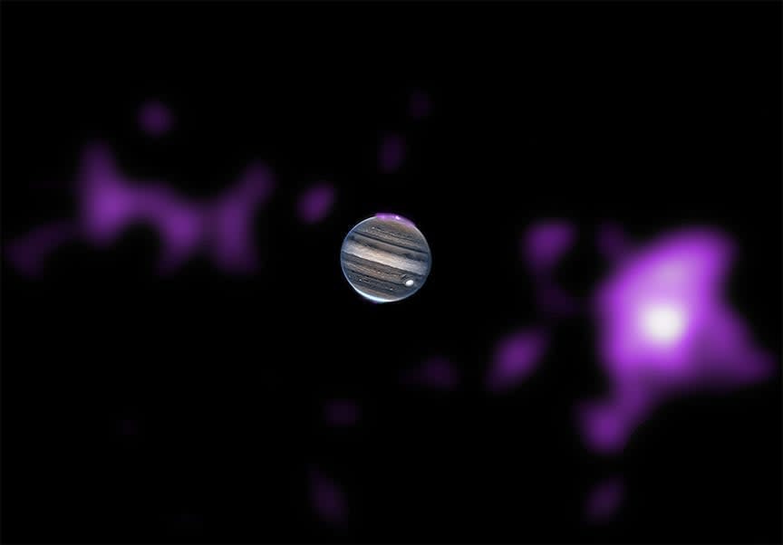 Jupiter im Weltraum mit einem violetten Dunst über seinem Nordpol und großen violetten Flecken, die teilweise größer als der Planet sind, links und rechts von ihm im fernen Weltraum