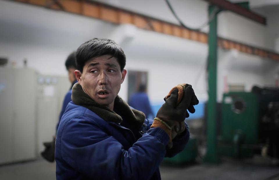 A factory worker takes off his gloves at the Pyongyang 326 Electric Wire Factory in Pyongyang, North Korea, on Jan. 10, 2017.