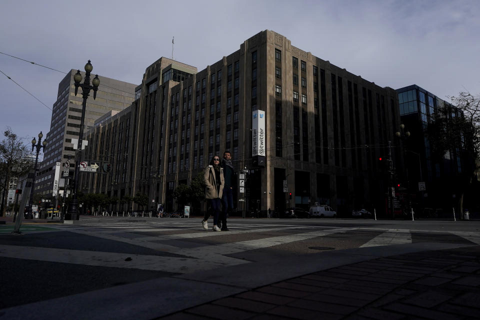 FILE - People cross the street in front of Twitter headquarters in San Francisco, Friday, Oct. 28, 2022. Employees were bracing for widespread layoffs at Twitter Friday, Nov. 4, as new owner Elon Musk overhauls the social platform. (AP Photo/Jeff Chiu, File)