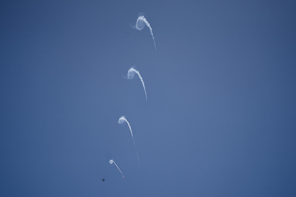 An Israeli Apache helicopter fires flares over the Gaza Strip on Friday, Dec. 1, 2023. (AP Photo/Ariel Schalit)