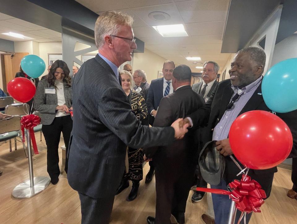 Rodney Reider, foreground left, CEO of Conemaugh Memorial Medical Center, shakes the hand of Michael Cashaw, a member of the hospital's advisory board, after the ribbon cutting ceremony.