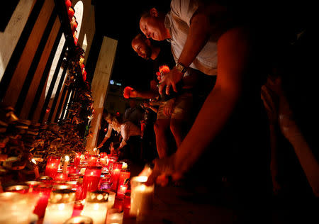 People place candles on the Love monument during a silent candlelight vigil to protest against the assassination of investigative journalist Daphne Caruana Galizia in a car bomb attack, in St Julian's, Malta, October 16, 2017. REUTERS/Darrin Zammit Lupi