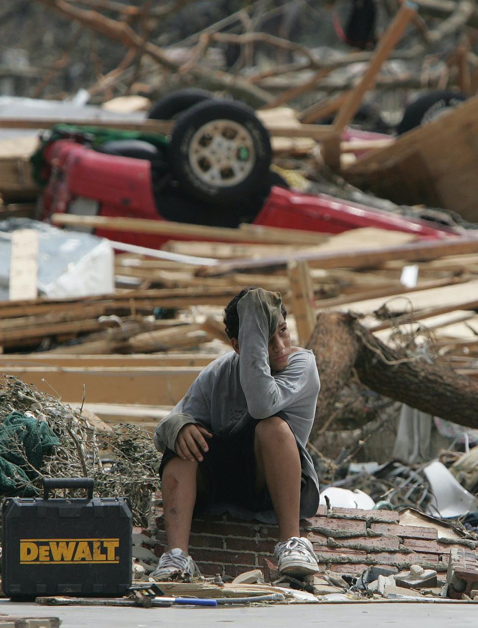 A 12-year-old sat in front of the remnants of a home damaged by Hurricane Katrina in 2005. <a href="https://newsroom.ap.org/detail/HURRICANEKATRINAAFTERMATH/ed1e24d441e1da11af9f0014c2589dfb/photo" rel="nofollow noopener" target="_blank" data-ylk="slk:AP Photo/John Bazemore;elm:context_link;itc:0;sec:content-canvas" class="link ">AP Photo/John Bazemore</a>