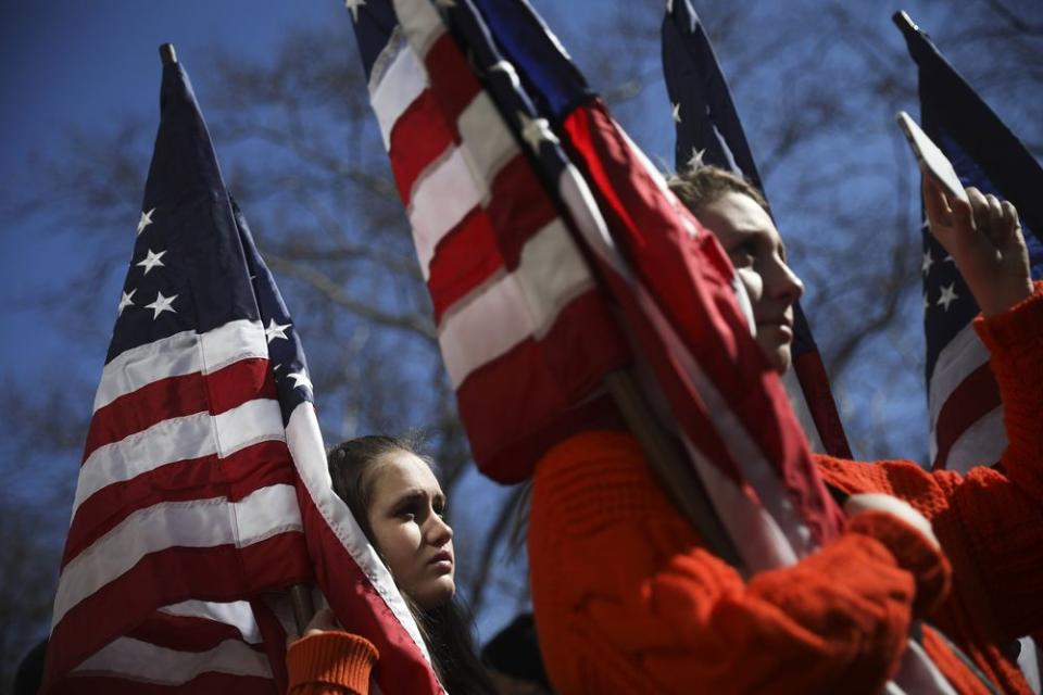 High school students from New Jersey hold American flags as they attend the March For Our Lives near Columbus Circle.