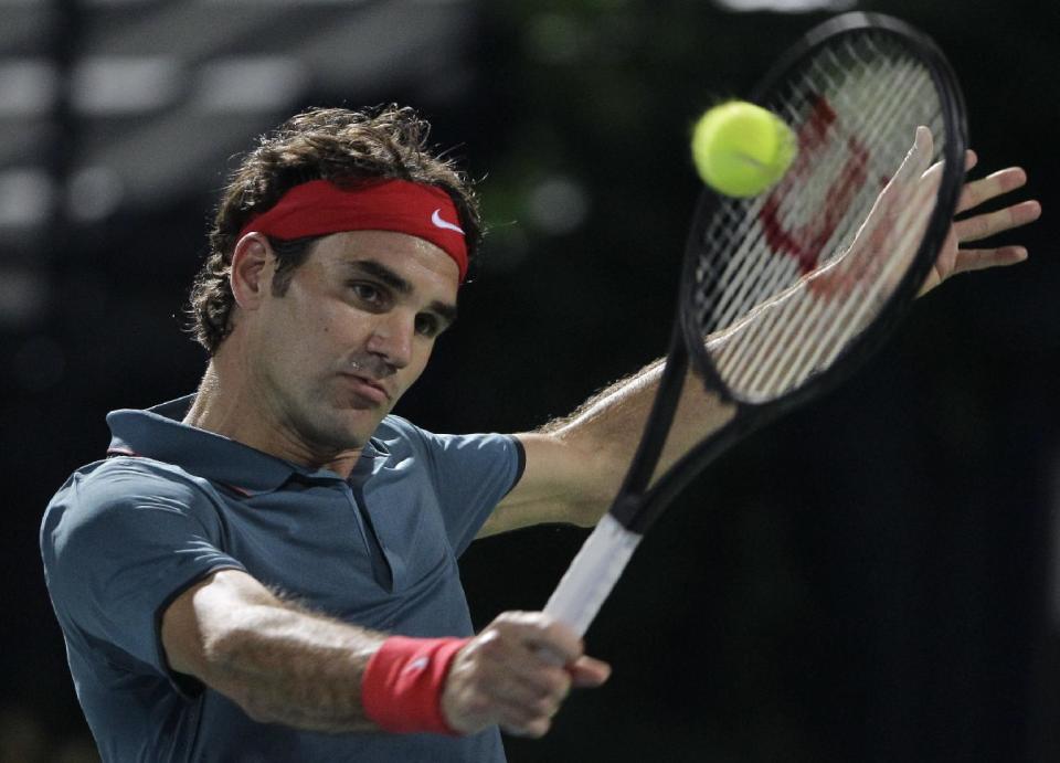 Roger Federer of Switzerland returns the ball to Novak Djokovic of Serbia during a semi final match of the Dubai Duty Free Tennis Championships in Dubai, United Arab Emirates, Friday, Feb. 28, 2014. (AP Photo/Kamran Jebreili)