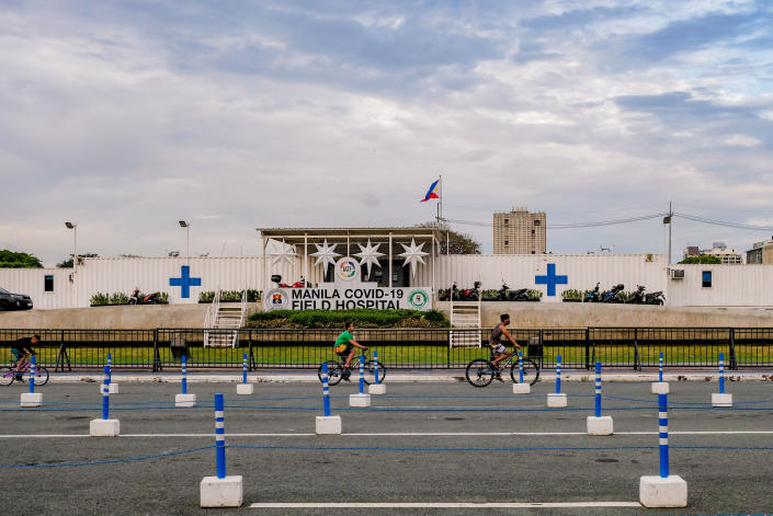 People engage in physical activities at an almost empty drive-thru vaccination site in Manila City, Philippines on February 23, 2022. Metro Manila mayors urged the national government to place the capital region under the loosest quarantine beginning March after achieving a 4.9% positivity rate, less than the World Health Organizations benchmark of 5% for opening economies. (Photo by George Calvelo/NurPhoto via Getty Images)