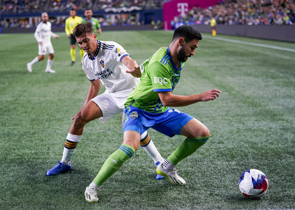 LA Galaxy defender Julián Aude (3) tries to work around Seattle Sounders midfielder Alex Roldan (16) for possession during the first half of an MLS soccer match Wednesday, Oct. 4, 2023, in Seattle. (AP Photo/Lindsey Wasson)