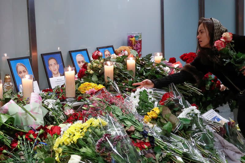 A woman places flowers at a memorial for the flight crew members of the Ukraine International Airlines Boeing 737-800 plane that crashed in Iran, at the Boryspil International airport