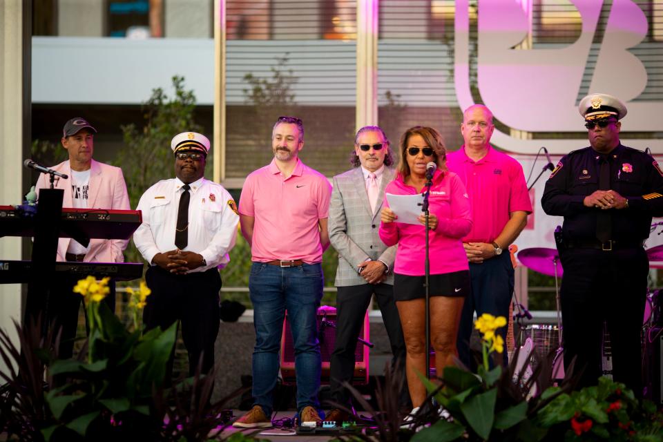 Real Men Wear Pink ambassadors stand on stage at the Paint the Square Pink event on Fountain Square to mark the start of Breast Cancer Awareness Month in 2021.