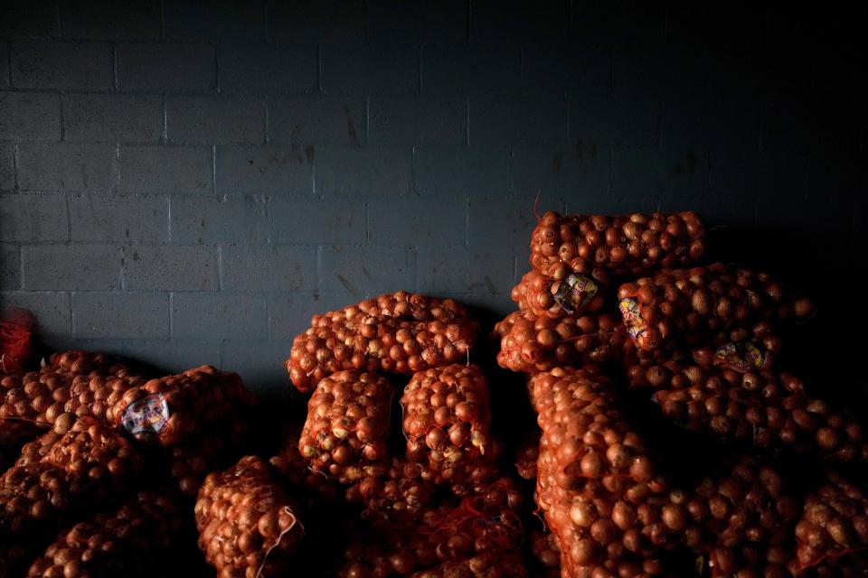 Sacks of onions are stacked against a wall at a market subsidized by the municipality so that residents can buy at lower prices amid rising inflation, in Lomas de Zamora, Argentina, Thursday, March 16, 2023. (AP Photo/Natacha Pisarenko)