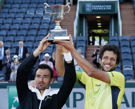 Ivan Dodig of Croatia (L) and Marcelo Melo of Brazil pose with their trophy after defeating Bob Bryan and Mike Bryan of the U.S. in their men's doubles final match at the French Open tennis tournament at the Roland Garros stadium in Paris, France, June 6, 2015. REUTERS/Pascal Rossignol