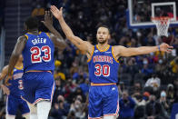 Golden State Warriors forward Draymond Green (23) celebrates with guard Stephen Curry (30) during the first half of an NBA basketball game against the Orlando Magic in San Francisco, Monday, Dec. 6, 2021. (AP Photo/Jeff Chiu)