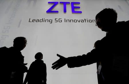 FILE PHOTO - Visitors pass in front of the Chinese telecoms equipment group ZTE Corp booth at the Mobile World Congress in Barcelona, Spain, February 26, 2018. REUTERS/Yves Herman/File Picture