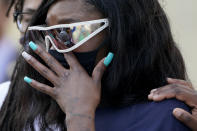 Deja Stallings wipes away tears during a news conference outside city hall Thursday, Oct. 8, 2020, in Kansas City, Mo. Protesters have occupied the lawn and plaza in front of city hall more than a week demanding the resignation of police chief Rick Smith and the officer who knelt on Stallings' back while arresting the pregnant woman last week. (AP Photo/Charlie Riedel)