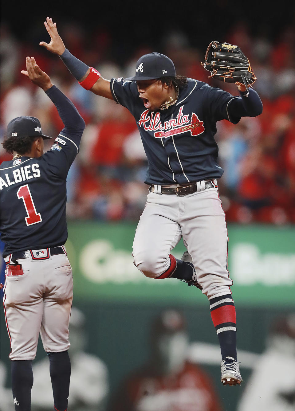 Atlanta Braves Ronald Acuña Jr., right, celebrates with Ozzie Albies after the team's 3-1 win over the St. Louis Cardinals in Game 3 of a baseball National League Division Series, Sunday, Oct. 6, 2019, in St. Louis. (Curtis Compton/Atlanta Journal-Constitution via AP)