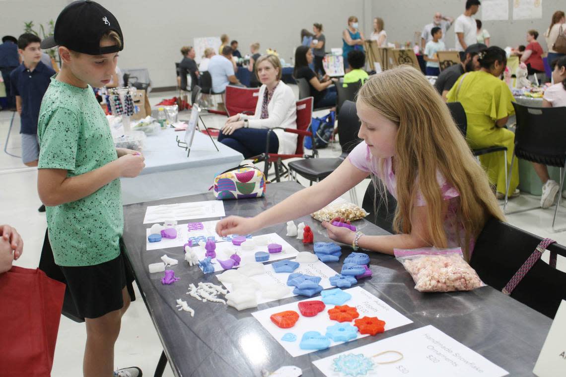 Micah Beck, 10, learns about 3-D printed fidget toys from Anna Beth Burns, 10, of Overland Park, during the KidsFest Business Fair in Shawnee Sept. 9. Beth Lipoff/Special to The Star
