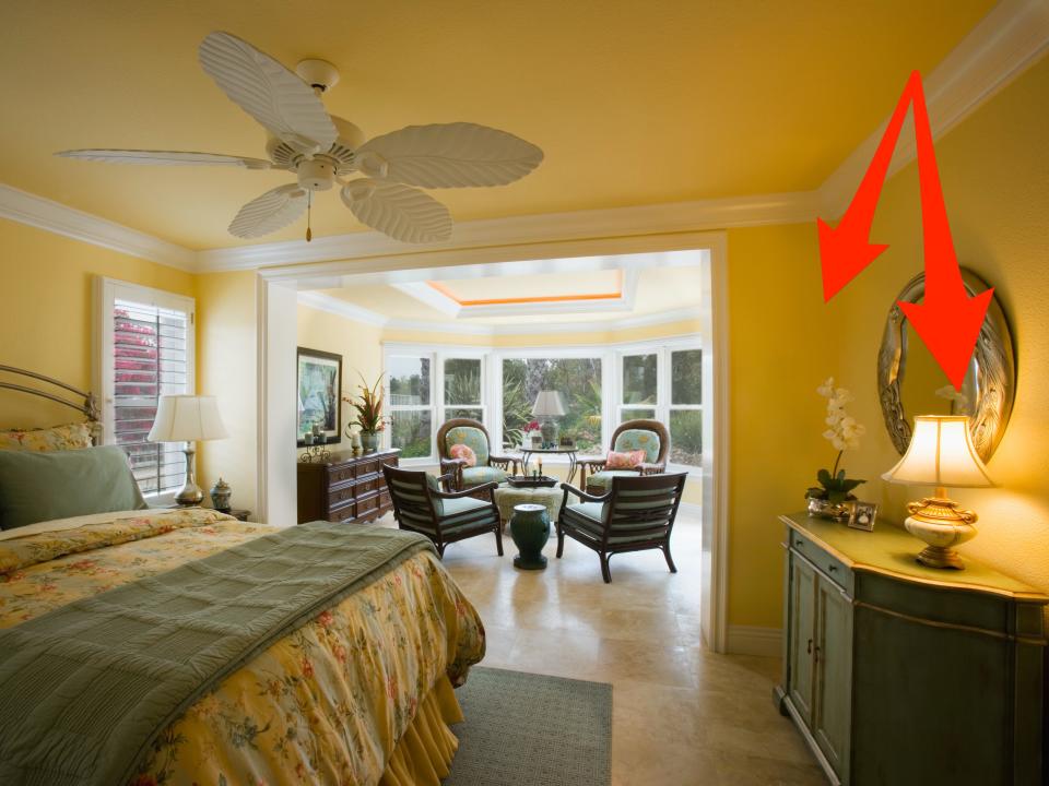 Red arrows pointing to a lamp and yellow walls in an all-yellow bedroom