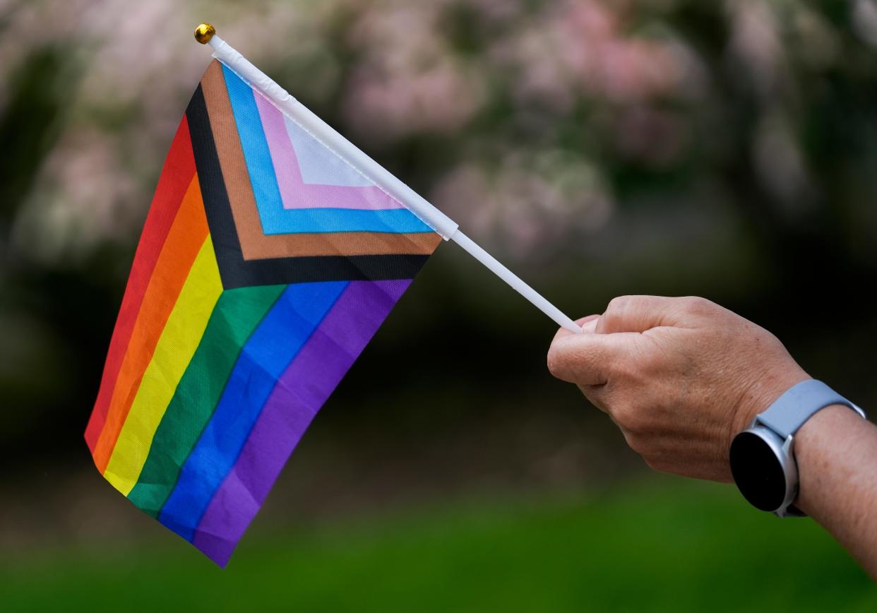 A person holds an Inclusive Rainbow flag as about 50 protesters gather outside the Ohio Statehouse as lawmakers debate two bills aimed at health care rights. One bill is HB 454, which would ban gender-affirming health care, such as gender reassignment surgery or the prescription of hormone blockers for people who are transgender. The other is HB 480, which would ban performing abortions. Joshua A. Bickel/Columbus Dispatch