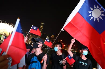 Anti-government protesters hold Taiwan national flags during a protest to celebrate Taiwan's National Day at the Harbour city in Tsim Sha Tsui district, in Hong Kong