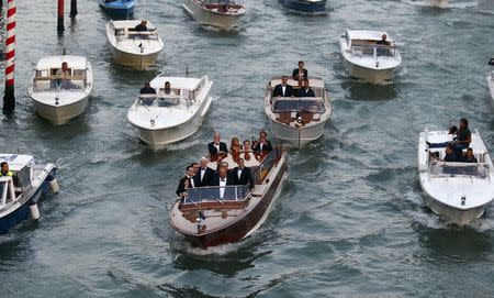 U.S. actor George Clooney (front boat, C) travels in a taxi boat in the Grand Canal in Venice, ahead of a gala dinner September 27, 2014. REUTERS/Stefano Rellandini