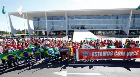 Supporters of outgoing Brazilian President Dilma Rousseff stand in front of the Planalto Palace after the Brazilian Senate vote to impeach of Rousseff for breaking budget laws, in Brasilia, Brazil, May 12, 2016. The banner reads, "We are with you". REUTERS/Paulo Whitaker