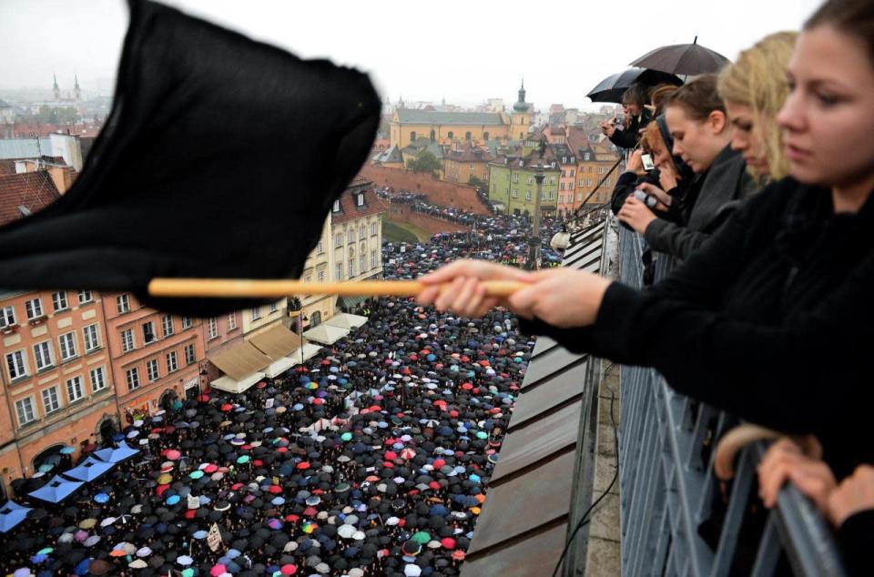 Una joven de Polonia agita una bandera negra mientras pasa una manifestación contra el proyecto legislativo de prohibición total del aborto, el lunes 3 de octubre de 2016 en Varsovia