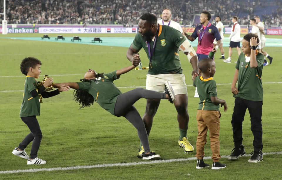 South Africa's Tendai Mtawarira celebrates with his children after defeating England in Rugby World Cup final at International Yokohama Stadium in Yokohama, Japan, Saturday, Nov. 2, 2019. (AP Photo/Mark Baker)