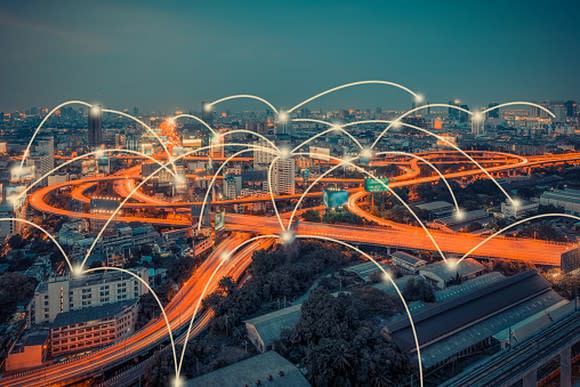 Picture of a city's cloverleaf highway glowing at night with multiple points connected by lines.