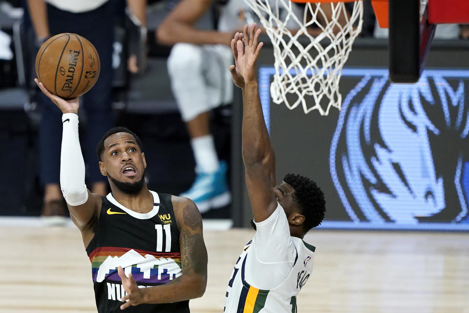 Denver Nuggets' Monte Morris (11) goes up for a shot against Utah Jazz's Emmanuel Mudiay during the first half of an NBA basketball first round playoff game, Monday, Aug. 17, 2020, in Lake Buena Vista, Fla. (AP Photo/Ashley Landis, Pool)