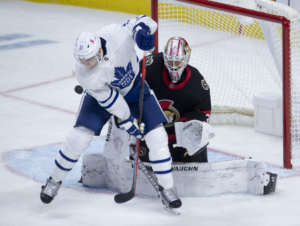 Toronto Maple Leafs left wing Zach Hyman (11) screens Ottawa Senators goaltender Matt Murray on a shot during the second period of an NHL hockey game in Ottawa, Ontario, Saturday, Jan. 16, 2021. (Adrian Wyld/The Canadian Press via AP)