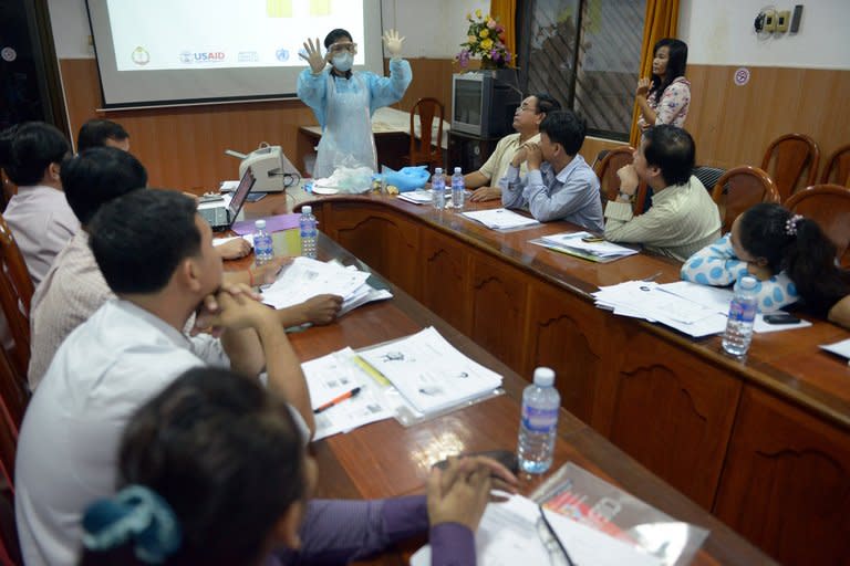 An expert teaches health officials how to detect bird flu cases early, south of Phnom Penh, on March 5, 2013. H5N1 causes a highly infectious, severe respiratory disease in birds. Humans can also be infected, typically through direct contact with sick poultry