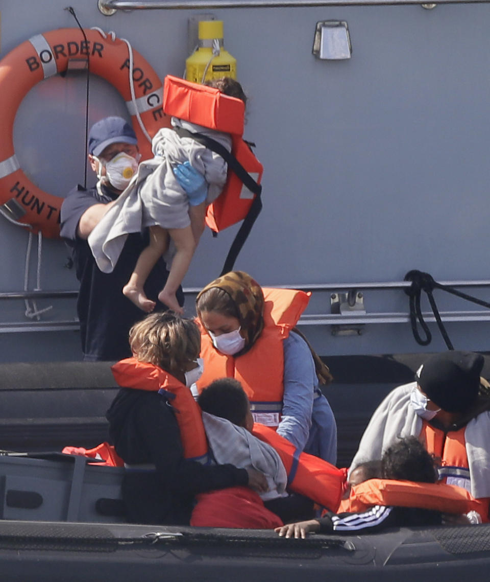 A Border Force vessel brings a group of people thought to be migrants into the port city of Dover, England, from small boats, Saturday Aug. 8, 2020. The British government says it will strengthen border measures as calm summer weather has prompted a record number of people to attempt the risky sea crossing in small vessels, from northern France to England. (AP Photo/Kirsty Wigglesworth)