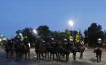 Serbian police on horses guard the area during clashes with protesters in Belgrade, Serbia, Wednesday, July 8, 2020. Serbia's president Aleksandar Vucic backtracked Wednesday on his plans to reinstate a coronavirus lockdown in Belgrade after thousands protested the move and violently clashed with the police in the capital. (AP Photo/Darko Vojinovic)