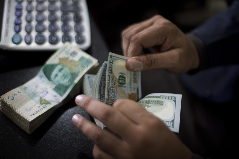 A Pakistani money changer counts US dollar bills in Islamabad, Pakistan, Friday, Nov. 30, 2018. Pakistan's currency has plunged further as the country is mired in a financial crisis and seeking an $8 billion bailout package from the International Monetary Fund. The Pakistani rupee was trading at 142 to the dollar on Friday, a decline from 133.90 rupees to $1 at close of business the previous day. (AP Photo/B.K. Bangash)