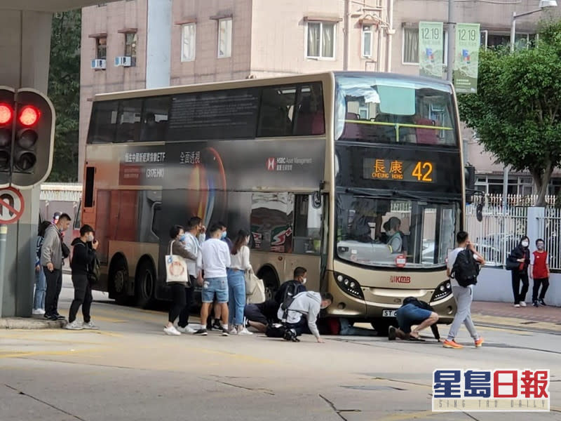 熱心途人蹲下察看車底的婦人。網民:Simon Chen