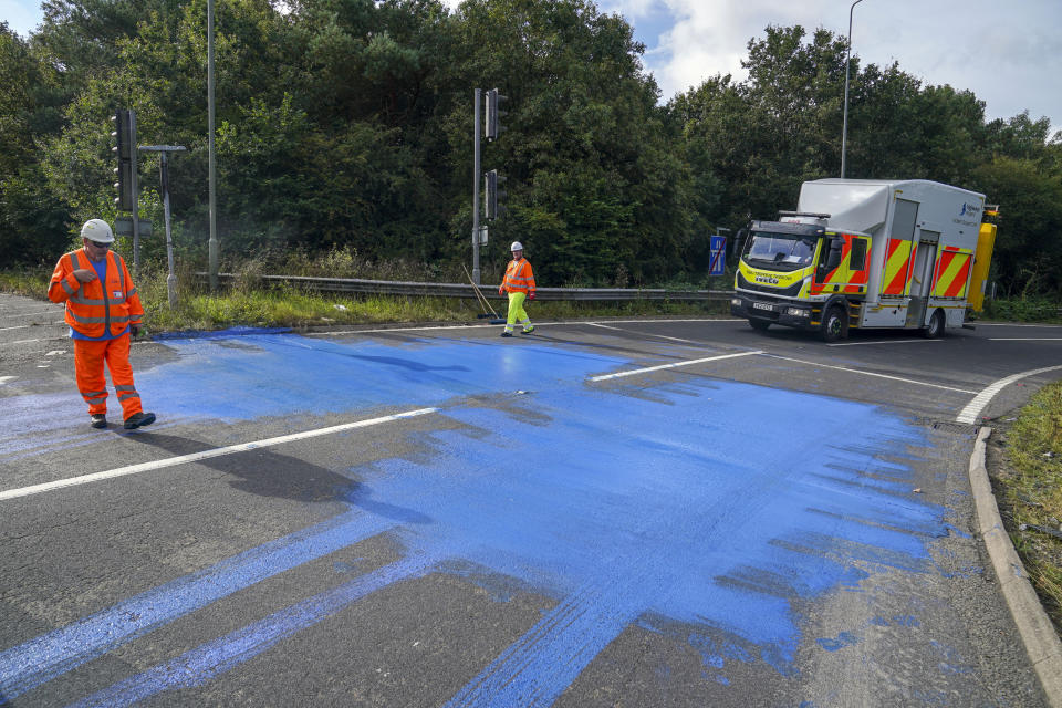 Highways England workers on the exit slip road of the M25 motorway near Leatherhead after protestors blocked the road and left paint on it. Picture date: Friday September 17, 2021.