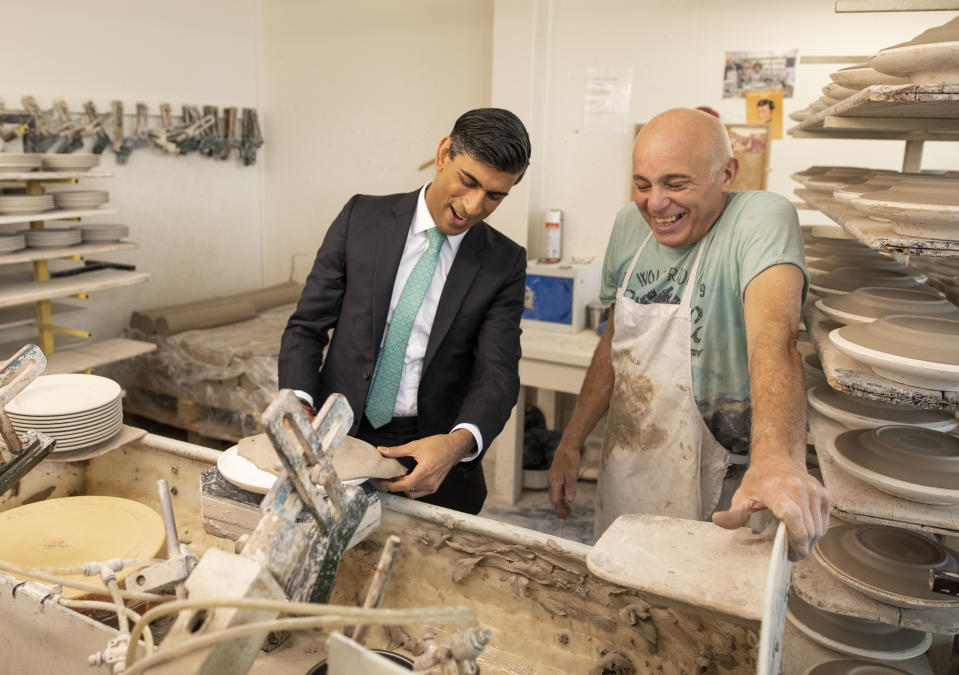 STOKE-ON-TRENT, ENGLAND - SEPTEMBER 14: Chancellor Rishi Sunak learns the art of handling clay to make plates with Wayne Swindaill during a visit to the Emma Bridgewater pottery after employees returned back to work after being furloughed on September 14, 2020 in Stoke-on-Trent, England. (Photo by Andrew Fox - WPA Pool / Getty Images)