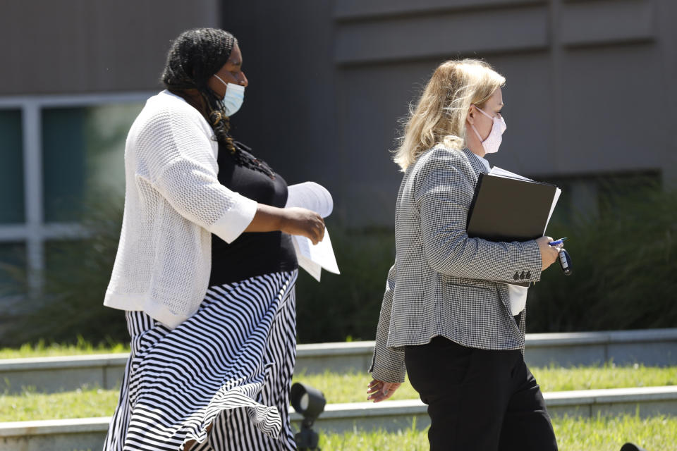 Carolyn Johnson, left, exits the Thad Cochran United States Courthouse in Jackson, Miss., Thursday, Aug. 6, 2020, accompanied by attorney Bethany Johnson, after being arraigned in federal court on immigration crimes and other federal charges stemming from the largest single-state worksite enforcement action last year at a number of Mississippi poultry processing plants. (AP Photo/Rogelio V. Solis)