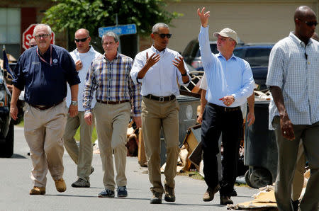 U.S. President Barack Obama (C), flanked by Federal Emergency Management Agency (FEMA) Administrator Craig Fugate (L) and U.S. Senator David Vitter (R-LA) (3rd L), speaks with Louisiana Governor John Bel Edwards (R) during a tour of a flood-affected neighborhood in Zachary, Louisiana, U.S., August 23, 2016. REUTERS/Jonathan Ernst